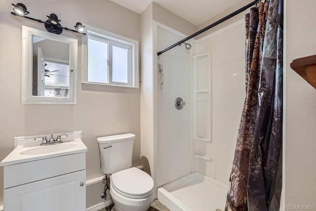 bathroom with toilet, a stall shower, and vanity