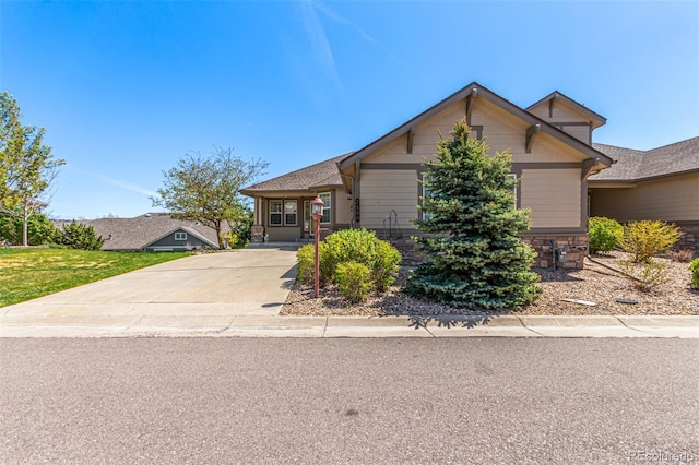 view of front of property with stone siding and driveway