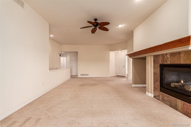 unfurnished living room featuring carpet, a tiled fireplace, a ceiling fan, baseboards, and recessed lighting