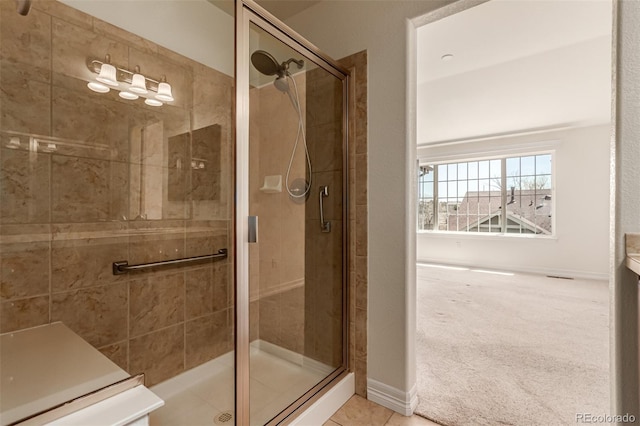full bath featuring a shower stall and baseboards