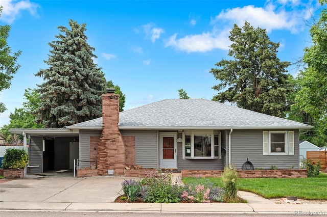 6755 W 45th Ave, Wheat Ridge, CO 80033 - view of front of home featuring driveway, an attached carport, a chimney, roof with shingles, and a front yard