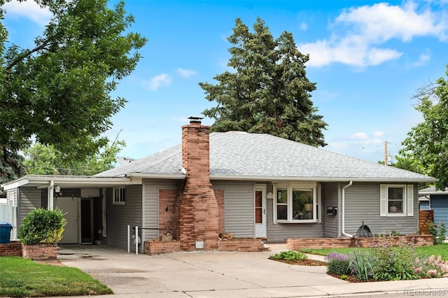 6755 W 45th Ave, Wheat Ridge, CO 80033 - view of front of home featuring concrete driveway, an attached carport, roof with shingles, and a chimney