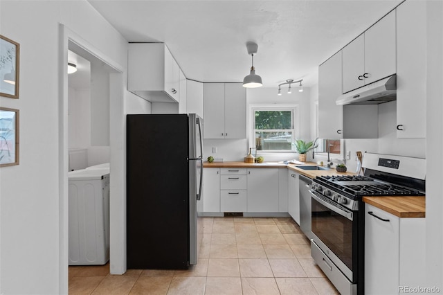 6755 W 45th Ave, Wheat Ridge, CO 80033 - kitchen featuring stainless steel appliances, under cabinet range hood, wooden counters, washer / clothes dryer, and white cabinets