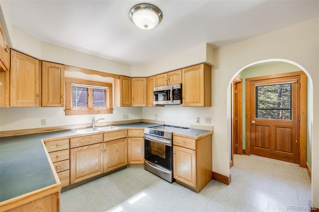 18247 State Highway 7, Lyons, CO 80540 - kitchen with appliances with stainless steel finishes, a sink, light floors, arched walkways, and light brown cabinets