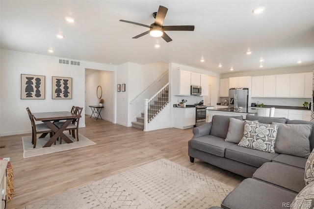 14818 Dahlia St, Thornton, CO 80602 - living room featuring stairs, recessed lighting, a ceiling fan, and light wood-style floors
