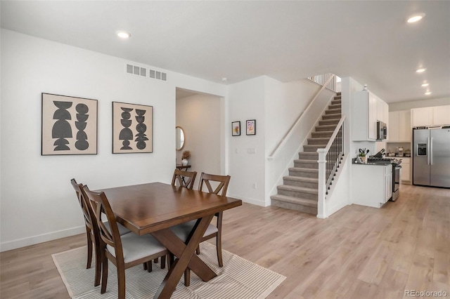 14818 Dahlia St, Thornton, CO 80602 - dining room featuring recessed lighting, light wood-style floors, and stairs