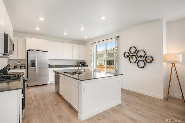 14818 Dahlia St, Thornton, CO 80602 - kitchen featuring appliances with stainless steel finishes, dark countertops, light wood-type flooring, white cabinets, and recessed lighting