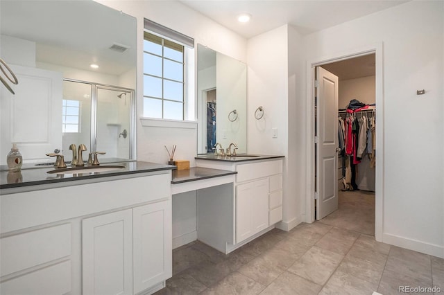 14818 Dahlia St, Thornton, CO 80602 - full bath featuring a stall shower, a walk in closet, and two vanities