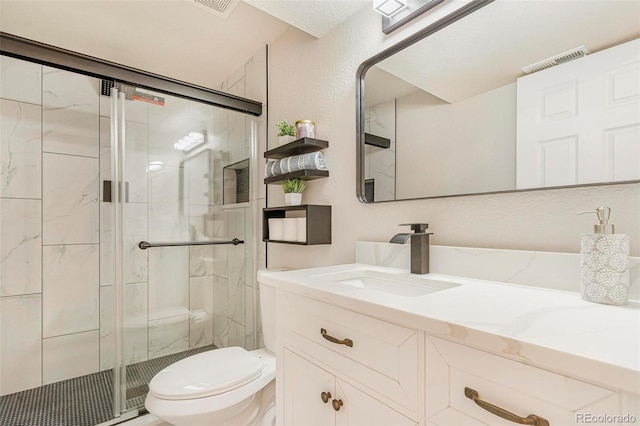 bathroom with vanity, a shower with shower door, and toilet