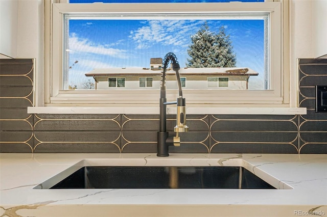 interior details featuring sink and light stone countertops