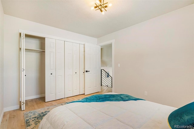 bedroom with light hardwood / wood-style floors and a closet