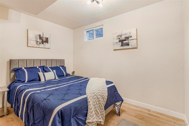 bedroom featuring hardwood / wood-style flooring and a textured ceiling