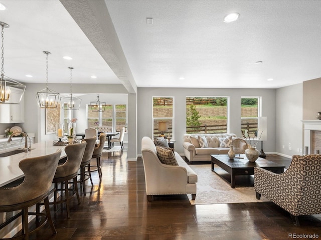 13041 Reata Ridge Dr, Parker, CO 80134 - living area featuring baseboards, dark wood-style flooring, recessed lighting, and a chandelier