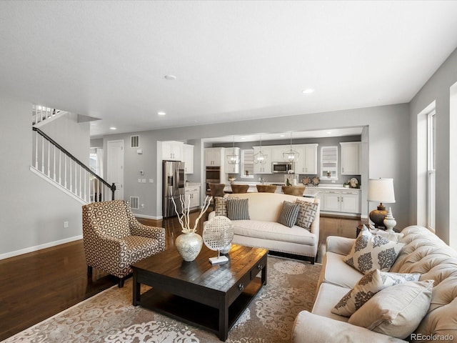 13041 Reata Ridge Dr, Parker, CO 80134 - living room featuring stairway, recessed lighting, dark wood-style floors, and visible vents