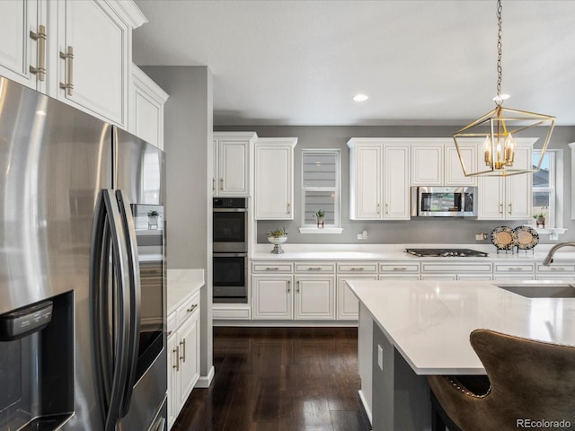 13041 Reata Ridge Dr, Parker, CO 80134 - kitchen with an inviting chandelier, a sink, light countertops, stainless steel appliances, and dark wood-type flooring