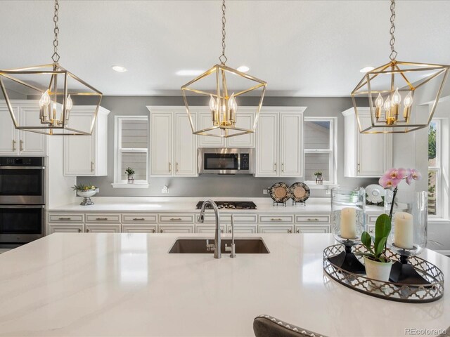 13041 Reata Ridge Dr, Parker, CO 80134 - kitchen with a sink, appliances with stainless steel finishes, a chandelier, and light countertops