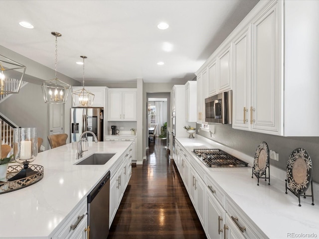 13041 Reata Ridge Dr, Parker, CO 80134 - kitchen featuring recessed lighting, white cabinetry, a sink, appliances with stainless steel finishes, and a notable chandelier