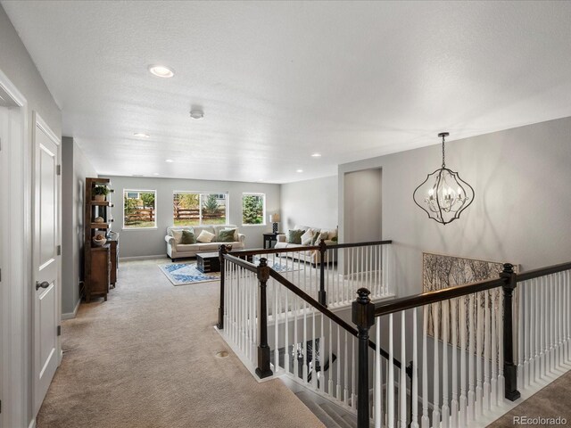 13041 Reata Ridge Dr, Parker, CO 80134 - hallway with recessed lighting, an upstairs landing, light carpet, and an inviting chandelier