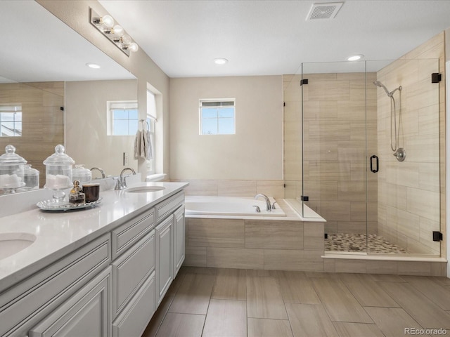 13041 Reata Ridge Dr, Parker, CO 80134 - full bath with a sink, double vanity, a shower stall, visible vents, and a garden tub