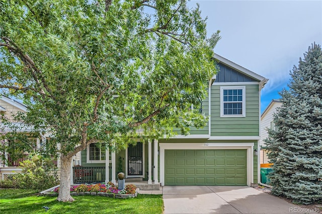 view of property hidden behind natural elements with a porch, a garage, and a front yard