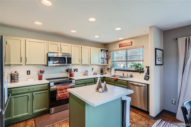 kitchen featuring dark hardwood / wood-style floors, a center island, sink, and appliances with stainless steel finishes