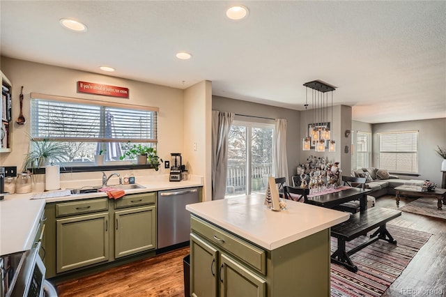 kitchen with light wood-type flooring, pendant lighting, green cabinetry, dishwasher, and a kitchen island