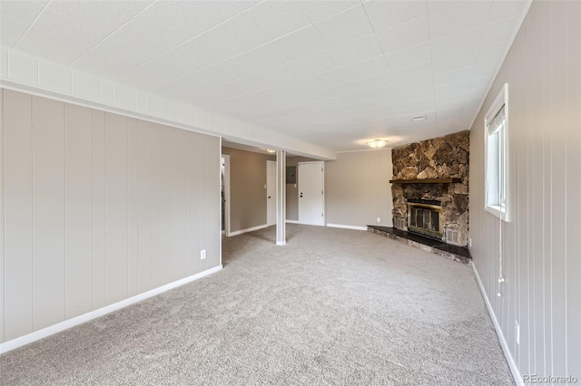 unfurnished living room featuring carpet flooring and a stone fireplace