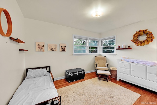 bedroom featuring wood finished floors and baseboards