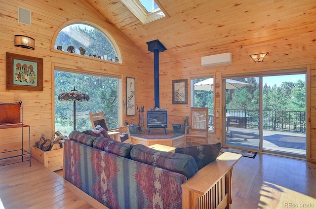 living room with a wall mounted air conditioner, a wealth of natural light, hardwood / wood-style flooring, wooden ceiling, and a wood stove