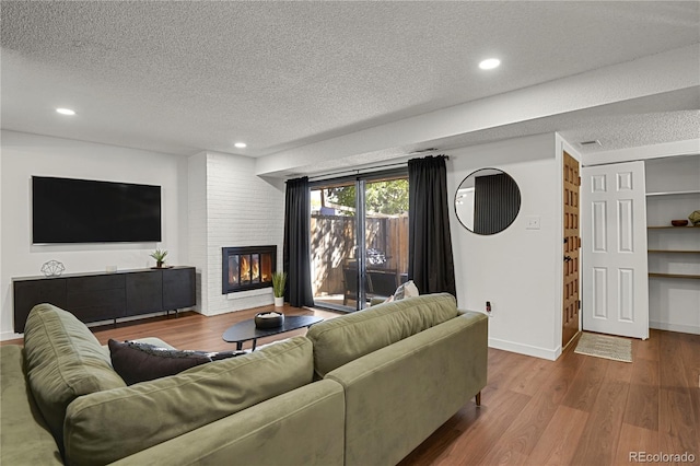 7995 E Mississippi Ave Unit K3, Denver, CO 80247 - living area with a textured ceiling, wood finished floors, recessed lighting, and a large fireplace