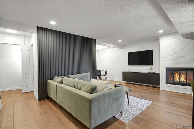 7995 E Mississippi Ave Unit K3, Denver, CO 80247 - living area with a textured ceiling, light wood finished floors, recessed lighting, and a fireplace