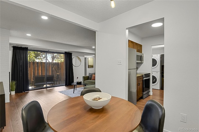 7995 E Mississippi Ave Unit K3, Denver, CO 80247 - dining room featuring stacked washer / dryer, light wood-style floors, and a textured ceiling