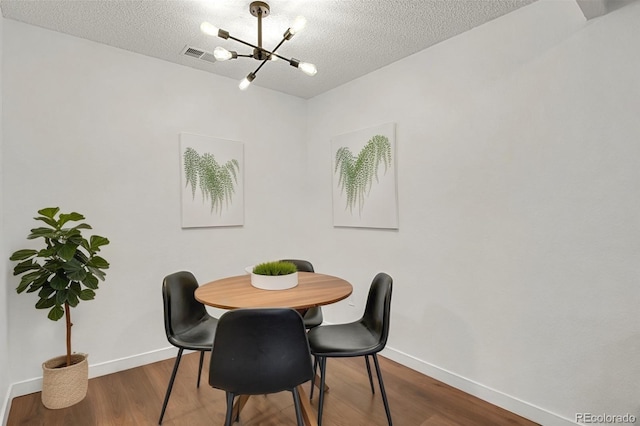 7995 E Mississippi Ave Unit K3, Denver, CO 80247 - dining area featuring a chandelier, wood finished floors, and a textured ceiling