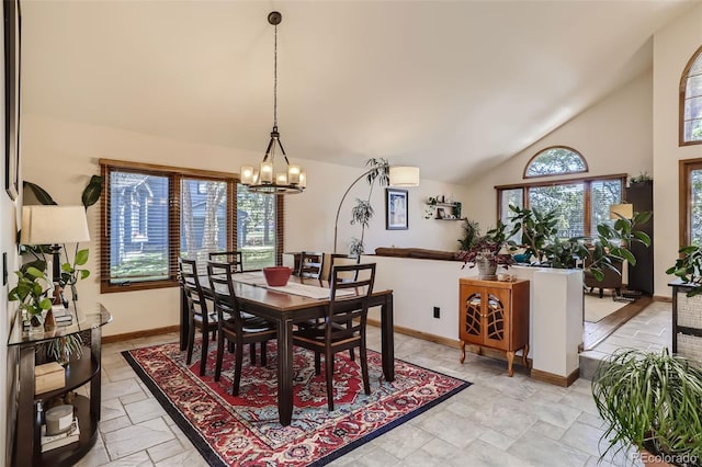 dining room with high vaulted ceiling, baseboards, a chandelier, and stone tile flooring