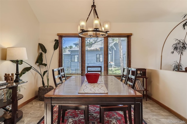 dining space with baseboards and a chandelier