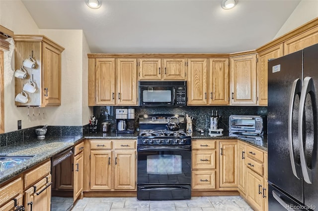 kitchen featuring a toaster, dark stone counters, decorative backsplash, lofted ceiling, and black appliances