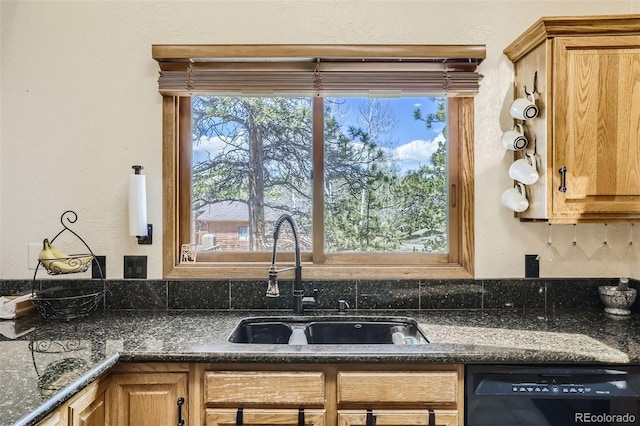 kitchen with a wealth of natural light, black dishwasher, dark stone counters, and a sink