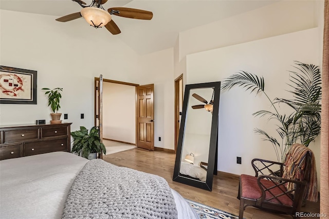 bedroom with light wood-style floors, a high ceiling, baseboards, and a ceiling fan