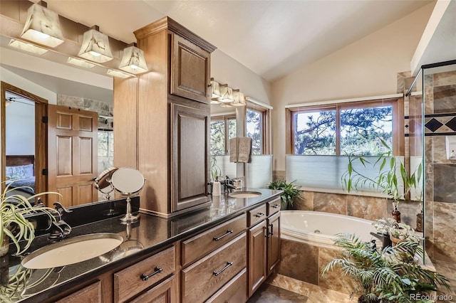 full bathroom with lofted ceiling, a stall shower, double vanity, and a sink