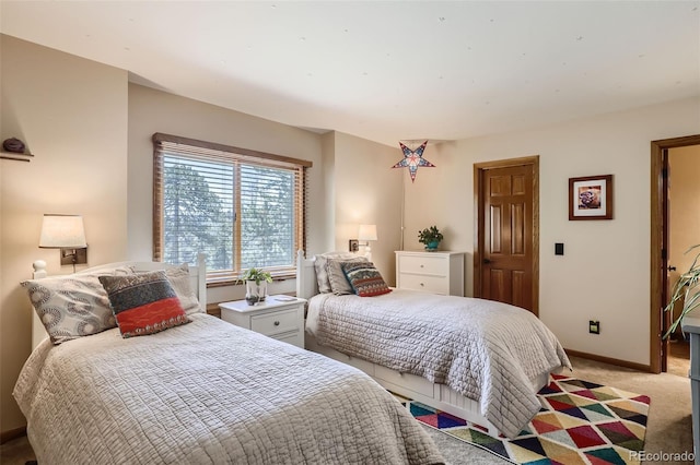 bedroom with light colored carpet and baseboards