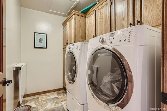 washroom featuring cabinet space, stone finish flooring, baseboards, and separate washer and dryer