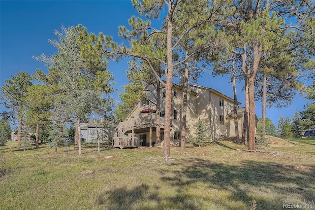 rear view of property with a deck and a yard