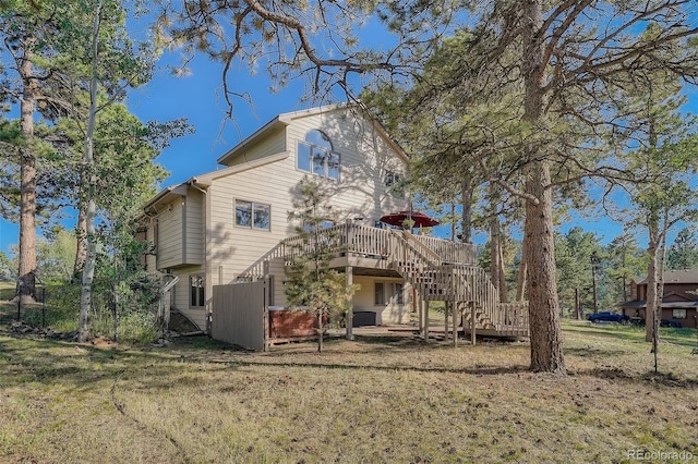 back of property with stairway, a deck, and a yard