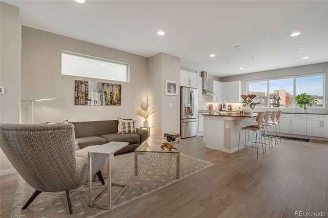 living area featuring light wood-style floors and recessed lighting