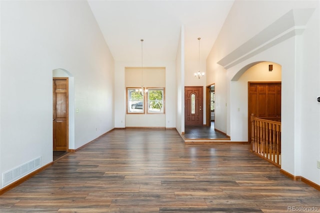 6668 Fairways Dr, Longmont, CO 80503 - entryway featuring a chandelier, high vaulted ceiling, wood finished floors, arched walkways, and baseboards