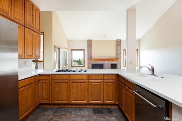 6668 Fairways Dr, Longmont, CO 80503 - kitchen with appliances with stainless steel finishes, a sink, light countertops, and a brick fireplace
