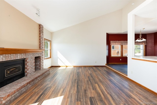 6668 Fairways Dr, Longmont, CO 80503 - unfurnished living room featuring vaulted ceiling, wood finished floors, a fireplace, a chandelier, and baseboards