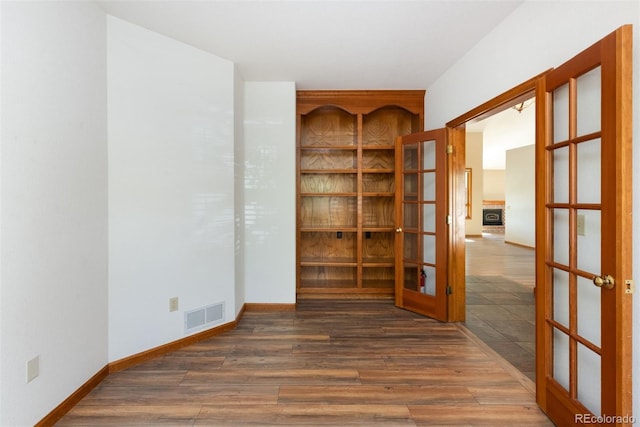 6668 Fairways Dr, Longmont, CO 80503 - spare room with french doors, wood finished floors, and baseboards