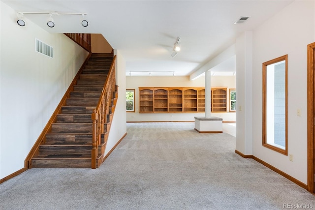6668 Fairways Dr, Longmont, CO 80503 - staircase featuring rail lighting, carpet flooring, and baseboards