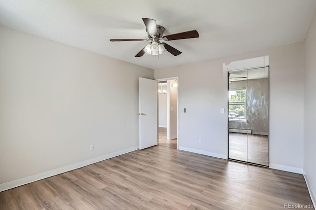 unfurnished bedroom featuring light wood-style floors, a closet, baseboards, and a ceiling fan